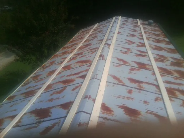 Rusted metal roof panels with new wood purlins before replacement — Storm Damage Roof Repair in Belleair Beach by Roofing Brothers